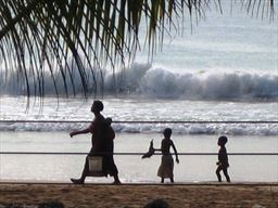 Woman walking with 2 children on beach
